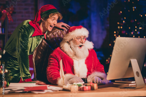 Fotografía Photo portrait of shocked santa claus and elf browsing internet on pc