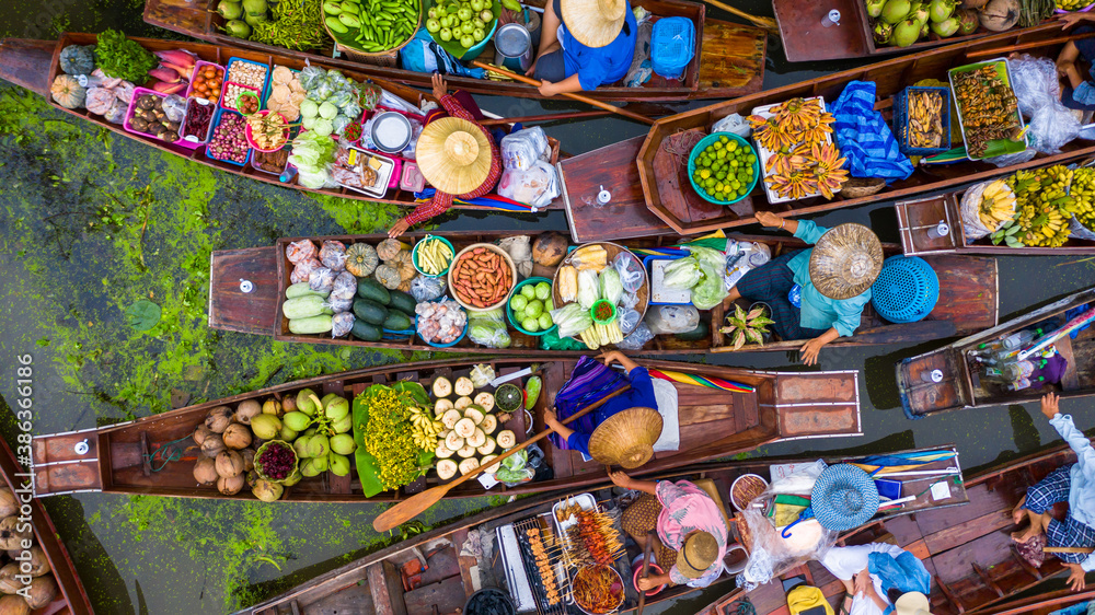 Naklejka premium Aerial view famous floating market in Thailand, Damnoen Saduak floating market, Farmer go to sell organic products, fruits, vegetables and Thai cuisine, Tourists visiting by boat, Ratchaburi, Thailand