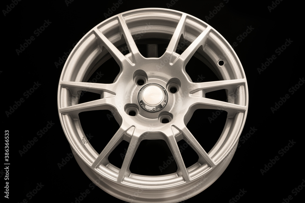 New silver alloy wheel on black background, front view