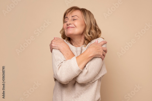 Cuadro en lienzo Senior caucasian woman hugging oneself happy and positive, smiling confident