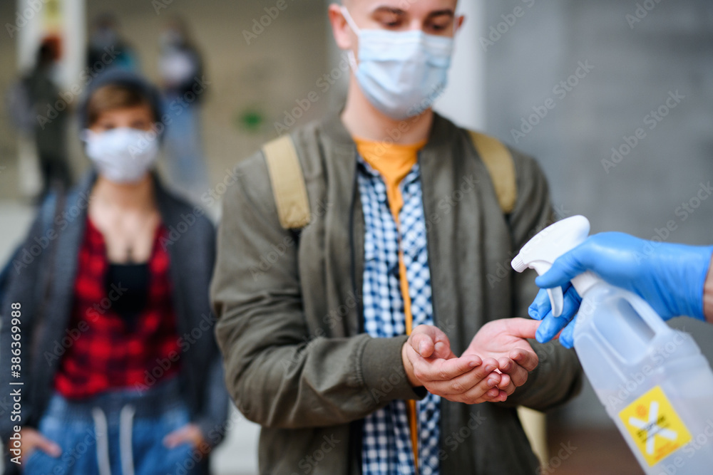 Young students back at college or university, coronavirus and disinfecting hands concept. Young students back at college or university, coronavirus and disinfecting hands concept.