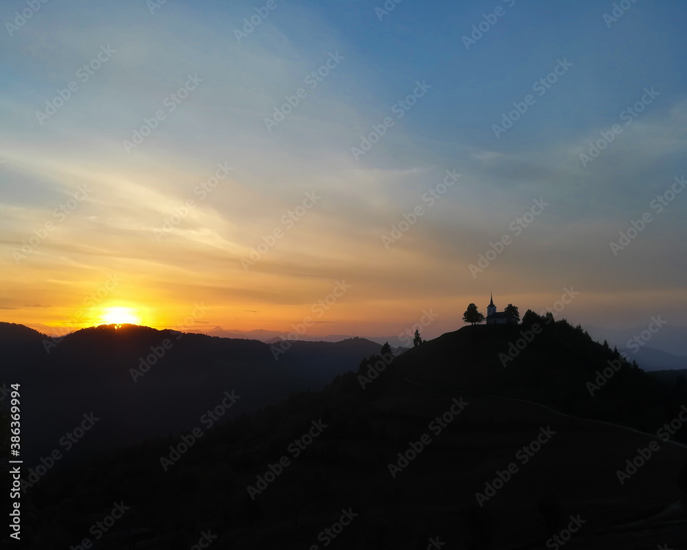 sunset over the mountains and church