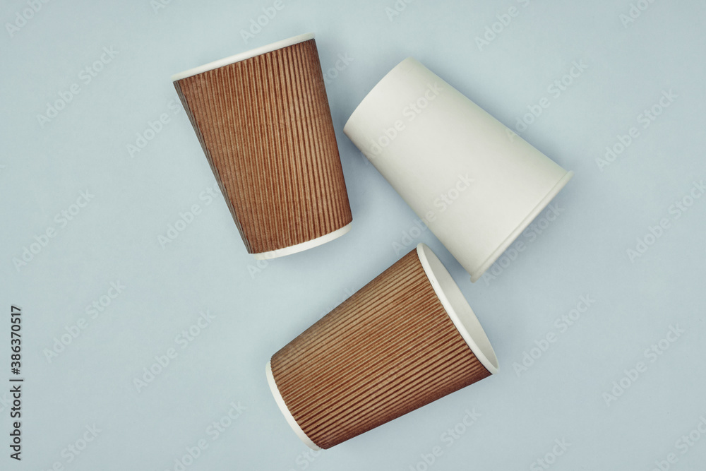 Paper cup in hand on a colored background. Eco-friendly materials in a ...