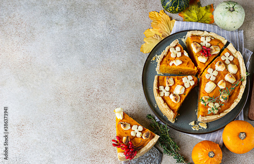 Top view of pumpkin tart or pie with feta cheese and thyme. Fall season concept. Cozy autumn food background. Copy space.