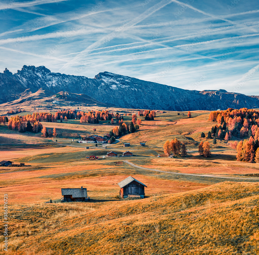 Magnificent outdoor scene in Seiser Alm Highland (Alpe di Siusi) with beautiful yellow larch trees and Rosengarten mountain range on background, Dolomite Alps, Ortisei locattion, Italy, Europe.