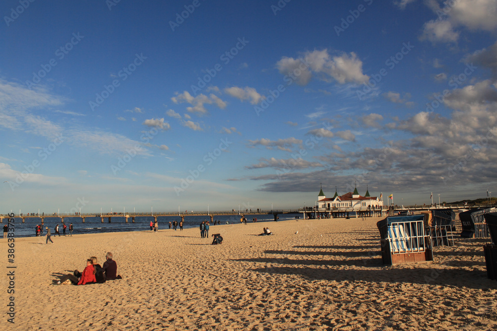 Obraz premium Herbstliche Abendsonne am Ostseestrand; Strandleben an der Seebrücke in Ahlbeck