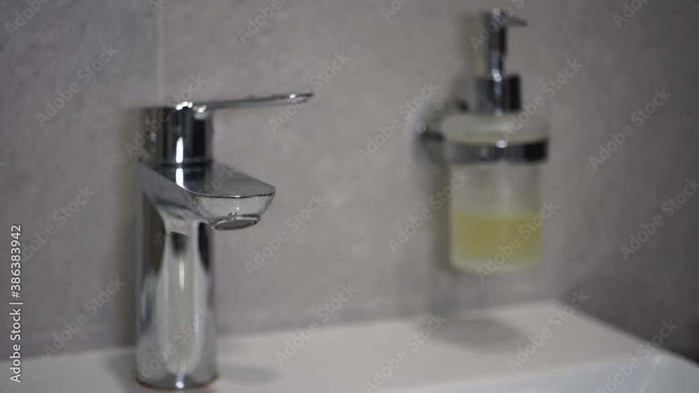 running tap water to the sink and in the background a disinfectant tank and men's hands are washed under water. and blurred background
running tap water to the sink and in the background a disinfectant tank and men's hands are washed under water. and blurred background