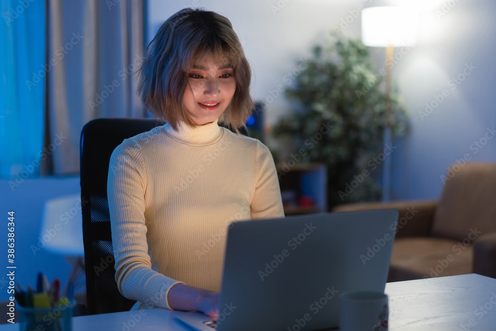 Asian woman Use your computer to play social network at night at her home. Asian woman Use your computer to play social network at night at her home.