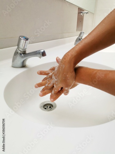 person washing hands in bathroom