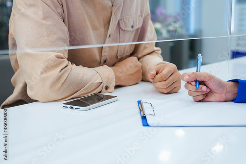 Crop shot - Customer talking to receptionist.