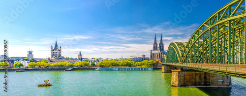 Panorama of Cologne city historical centre with Cologne Cathedral of Saint Peter, Great Saint Martin Roman Catholic Church buildings and Hohenzollern Bridge across Rhine river. Cologne panoramic view photo