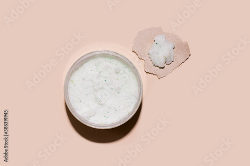 Body and face scrub on a beige background. View from above.