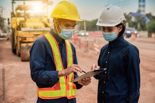 Two Engineer holding tablet talking on site construction