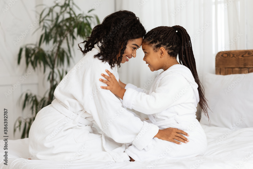 Fototapeta premium Loving Black Mother Bonding With Her Little Daughter On Bed At Home