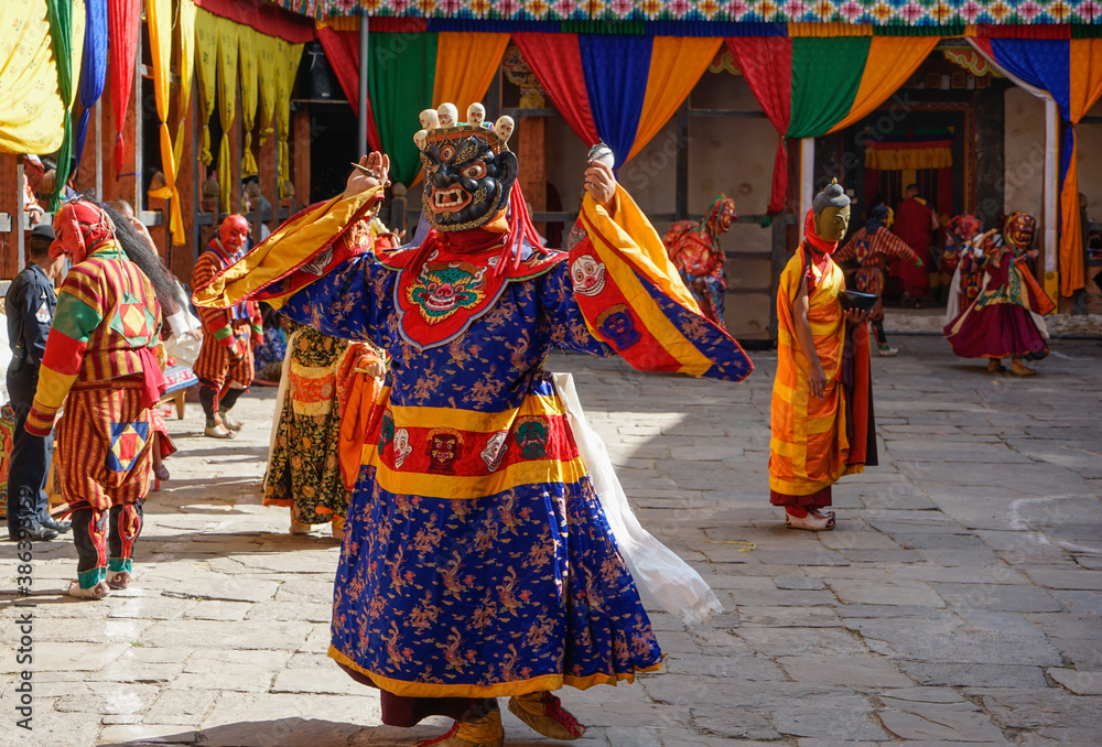 Bhutan,  in the village of Bumthang, a monk mask dancer in his colourful costume dances at the festival of Jakar.