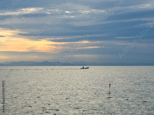 夕景の海を走る漁船