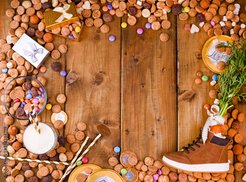 Sinterklaas. Dutch holiday postcard. Wooden background with childrens shoe with carrots for Santa's horse, pepernoten and sweets . View from above. Copy space. High quality photo photo