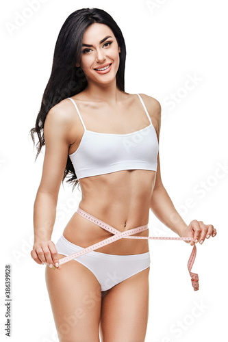 Slim tanned woman's body isolated on white background - waist measurement
