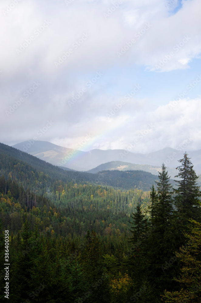 Autumn landscape in the mountains with a rainbow. Carpathian Mountains, Ukraine.