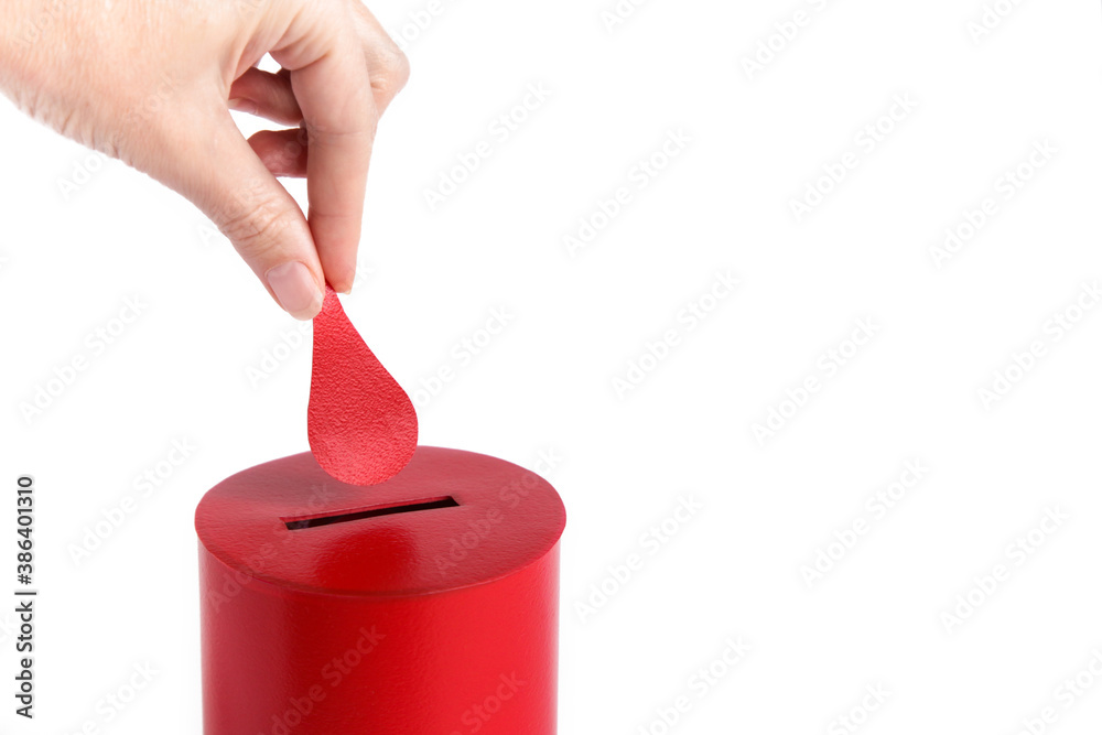 Obraz premium Blood donor. Hand puts drop of blood in the Box as donation on white background. Concept donate blood save life. Close up. Copy space