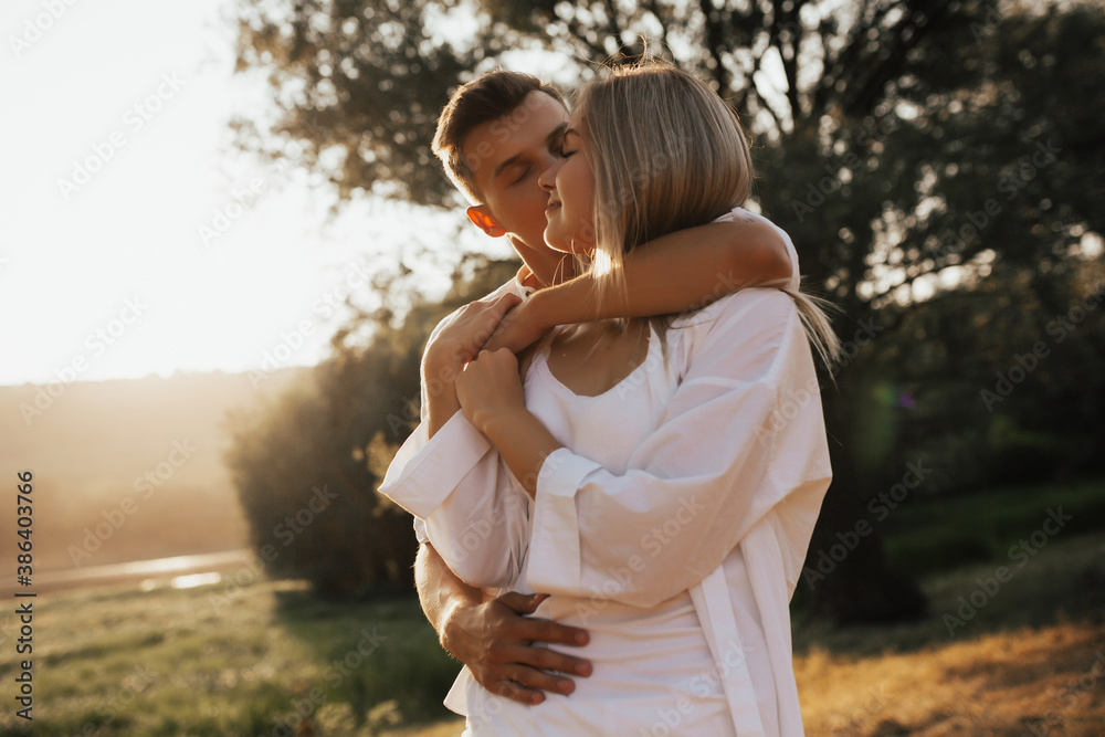 Close up portrait of cute lovely couple enjoying each other with closed eyes. Man kissing him girlfriend on the cheek.