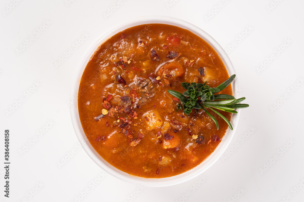 Borscht soup in a white bowl on white background. Top view. Famous traditional Ukrainian and Russian soup with beetroot and cabbage. Borscht soup in a white bowl on white background. Top view. Famous traditional Ukrainian and Russian soup with beetroot and cabbage.