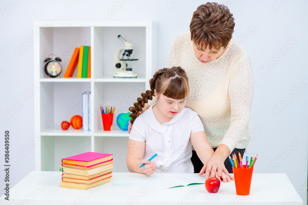 Girl with Down Syndrome works with her teacher at home Girl with Down Syndrome works with her teacher at home