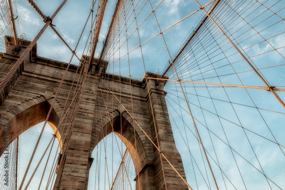 Obraz premium Supports of the Brooklyn Bridge. Geometry of the lines of support ropes and arches against a dramatic sky in New York, USA.