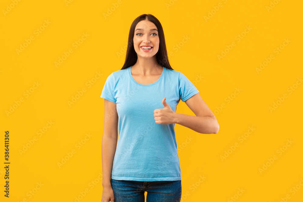 Happy woman gesturing thumbs up and smiling Happy woman gesturing thumbs up and smiling