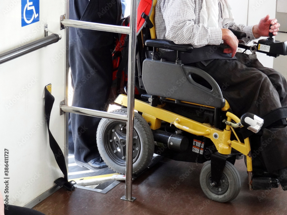 電動車椅子の下車を手伝う乗客