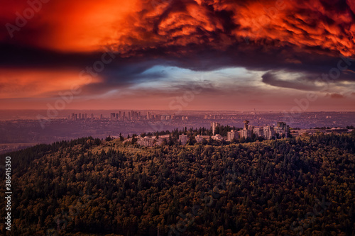 Aerial view of Burnaby Mountain during a vibrant sunset. Taken in Greater Vancouver  British Columbia  Canada. Modern City viewed from Above. Dramatic Sky Artistic Render