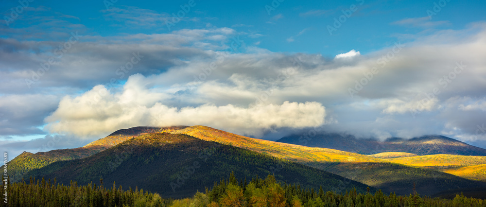 Panoramic autumn landscape in the Brooks Range, Alaska with mountains partly shrouded in clouds 