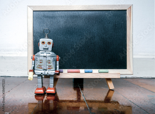 robot and a  blacboard on a wooden floor photo