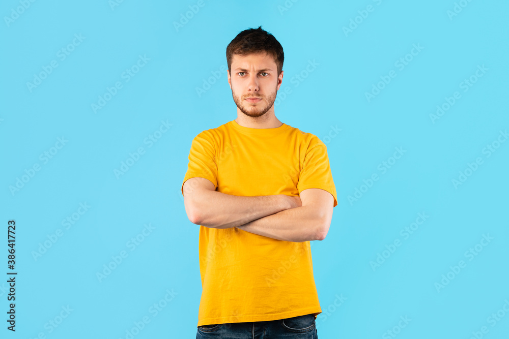 Portrait of offended man standing with folded arms Portrait of offended man standing with folded arms