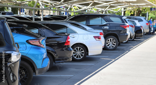 Closeup of rear, back side of blue car with  other cars parking in parking lot in bright sunny day.  © Amphon