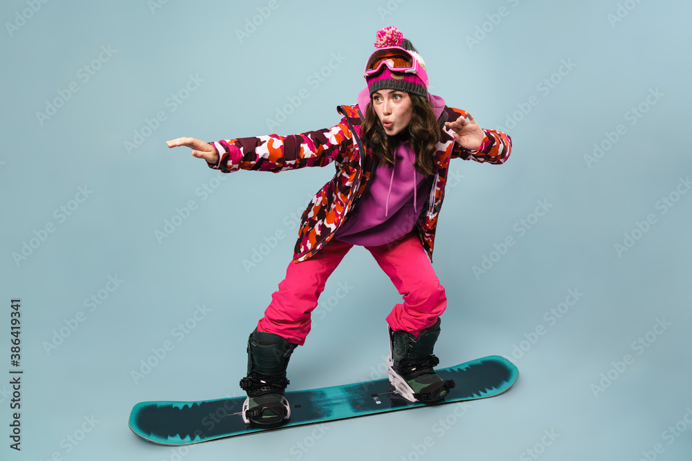 Caucasian focused young sportswoman snowboarding