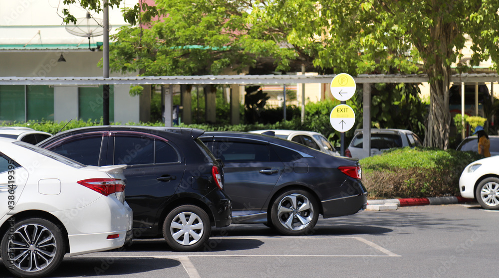 Closeup of rear side of white car with  other cars parking in outdoor parking area with natural background. 