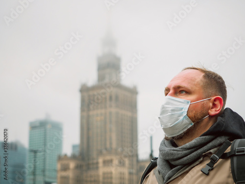 adult european man wearing a mask outdoor near Palace of Culture and Science in Warsaw city in Poland