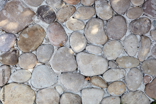 Stone road texture. Cobblestone. Ancient stone floor texture, oval shape, top view