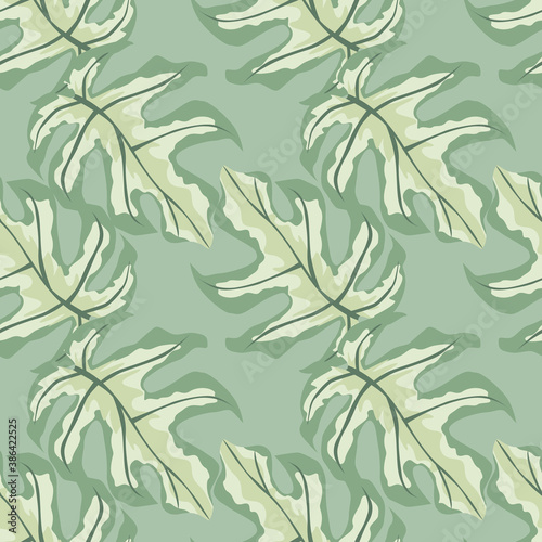 Pastel tones seamless doodle pattern with monstera ornament. Tropical leaves silhouettes with light green exotic print.