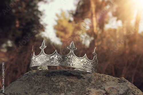 mysterious and magical photo of silver king crown in the England woods over stone. Medieval period concept.