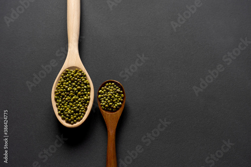 Two wooden spoons with mung bean.