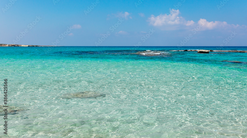 Beautiful beach with crystal clear blue waters against blue sky