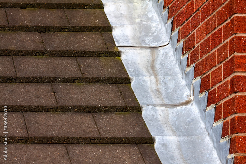Fotka „Stepped lead flashing roof gulley creating a water tight seal