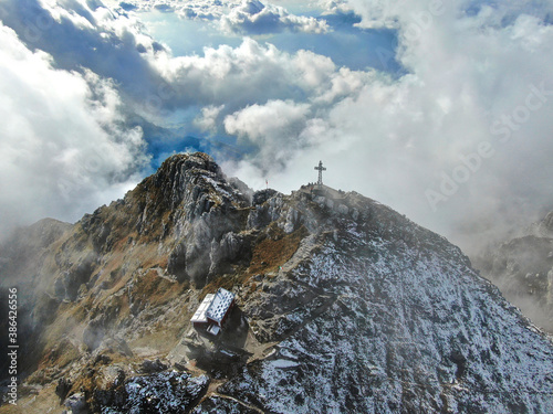An aerial panorama of the peak of Mount Resegone next to Lecco, surrounded by clouds photo