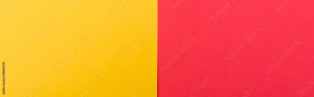 Fototapeta premium top view of colorful abstract yellow, red paper background, panoramic shot