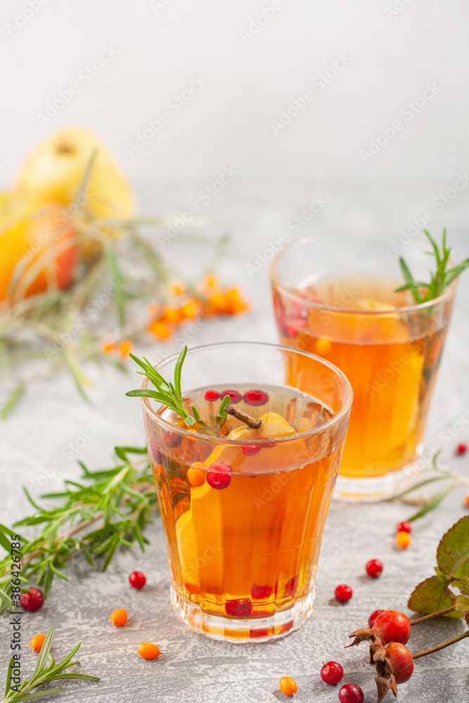 Winter or autumn hot healing tea with pear, orange, lingonberries, sea buckthorn and spices in glass cup. Winter or autumn hot healing tea with pear, orange, lingonberries, sea buckthorn and spices in glass cup.