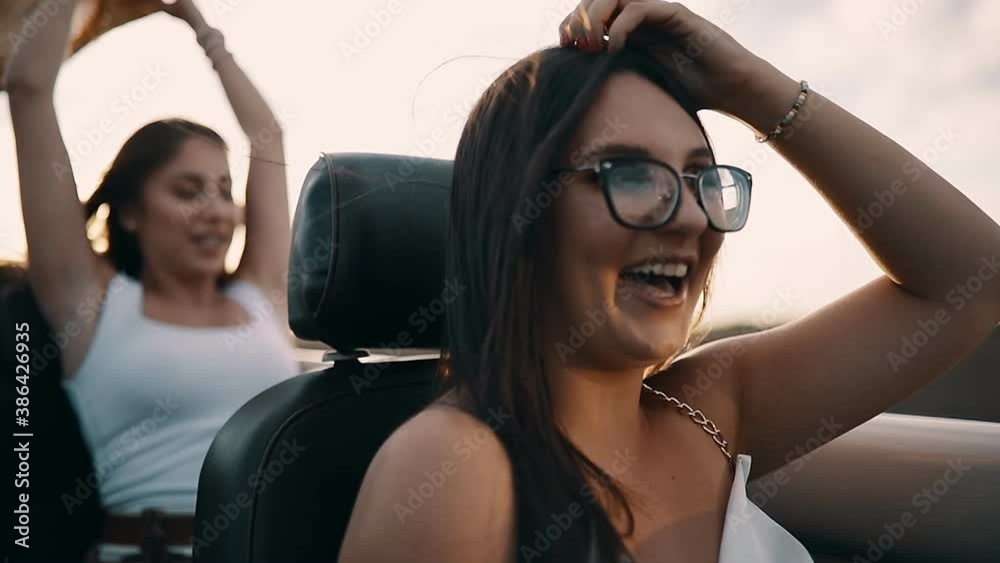 Slow motion shot of two young women traveling in a car and singing Slow motion shot of two young women traveling in a car and singing