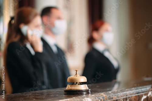 Check in hotel. receptionist at counter in hotel wearing medical masks as precaution against virus. Young woman on a business trip doing check-in at the hotel