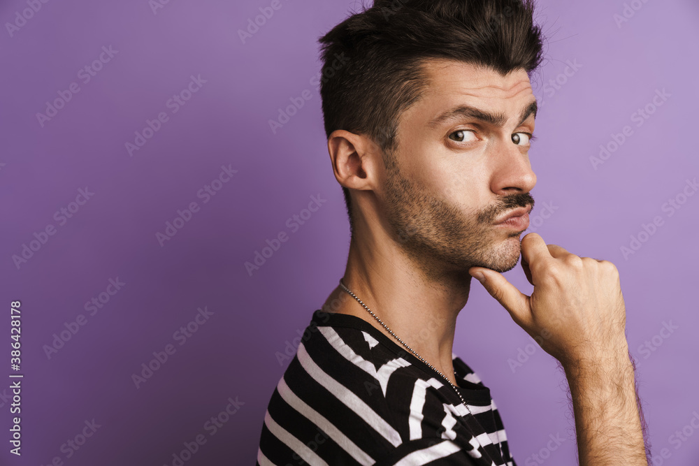 Photo of thinking young man posing and looking at camera Photo of thinking young man posing and looking at camera